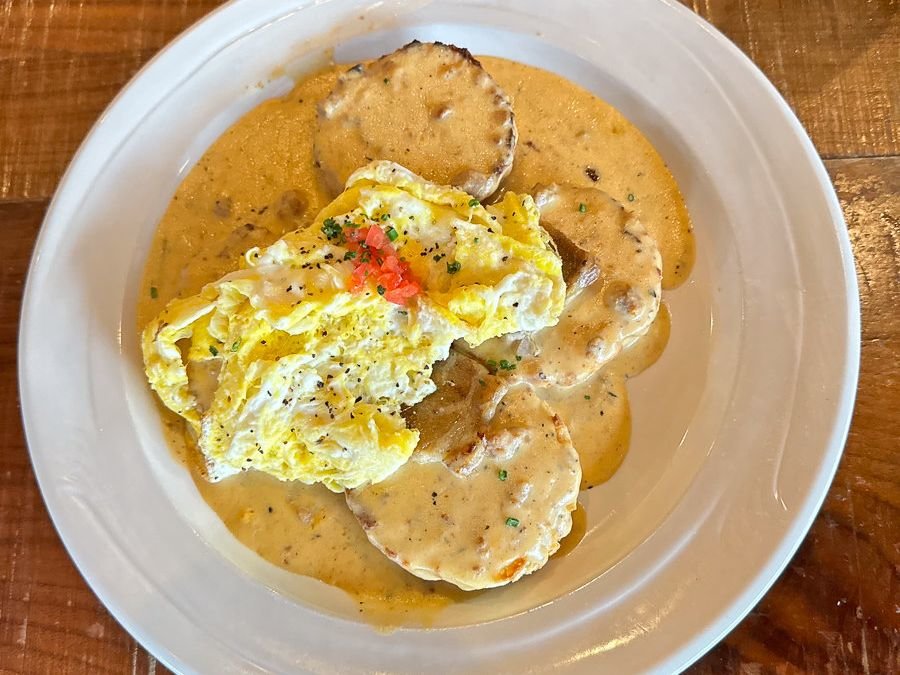biscuits with gravy and scrambled eggs on a white plate